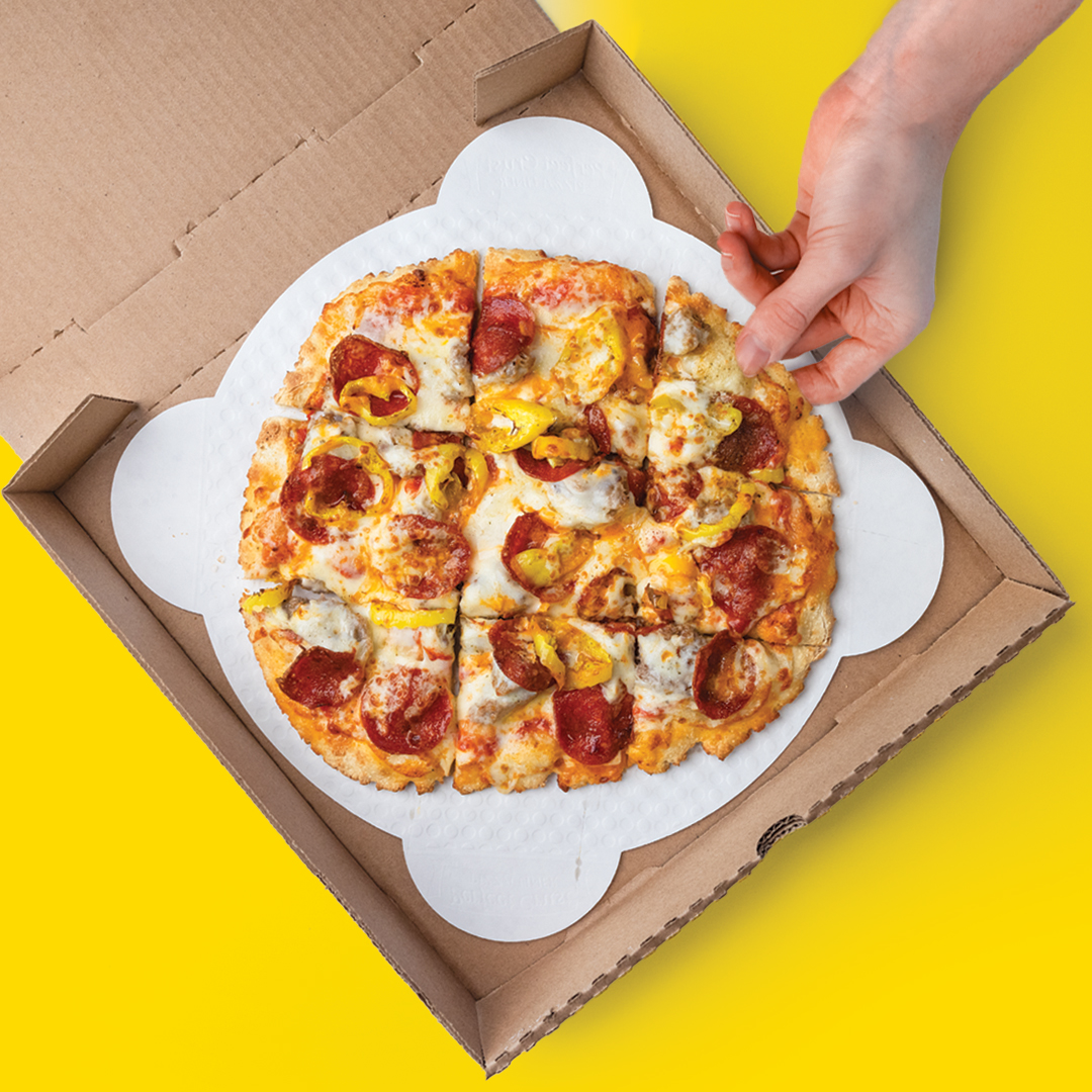A slice of The Founder pizza being pulled from a pizza box. Now offering dine-in, carryout, and delivery.